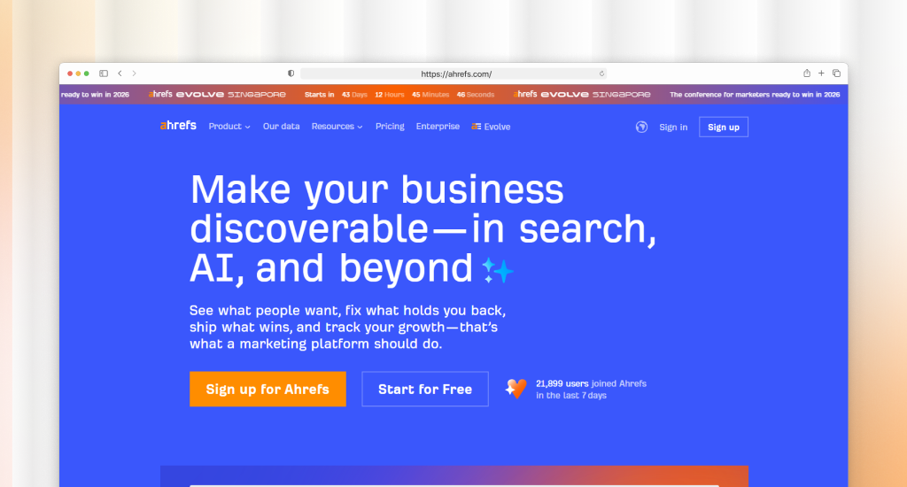 Ahrefs homepage with blue background, headline "Make your business discoverable—in search, AI, and beyond," orange "Sign up" and "Start for Free" buttons, and a 21,000+ weekly users badge.